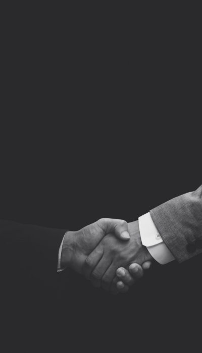 Business partners shaking hands monochrome